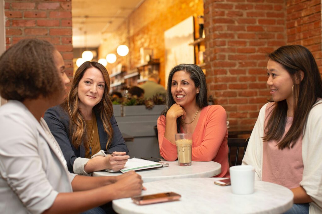 Women sitting around table talking.