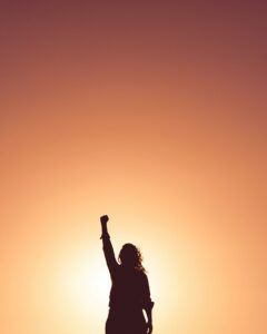 Person holding up fist with sunset background